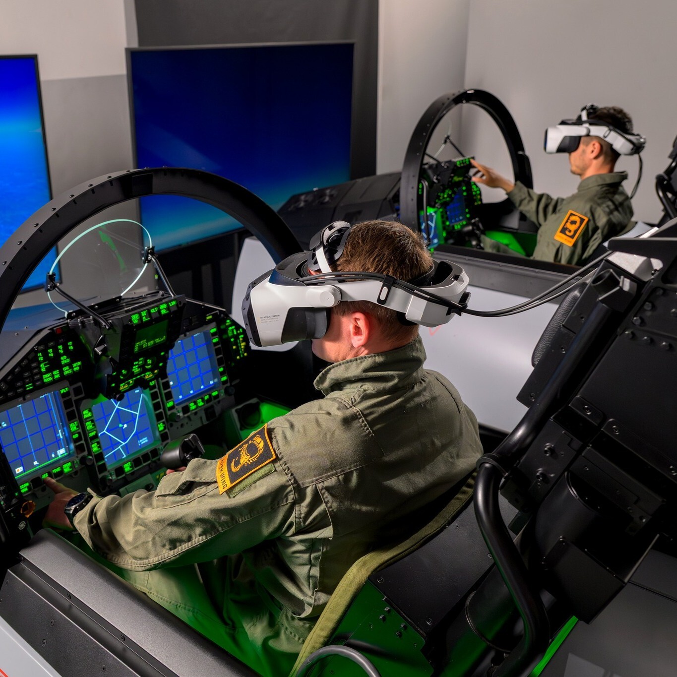Two people sitting in flight simulators, wearing Varjo XR-4 headsets