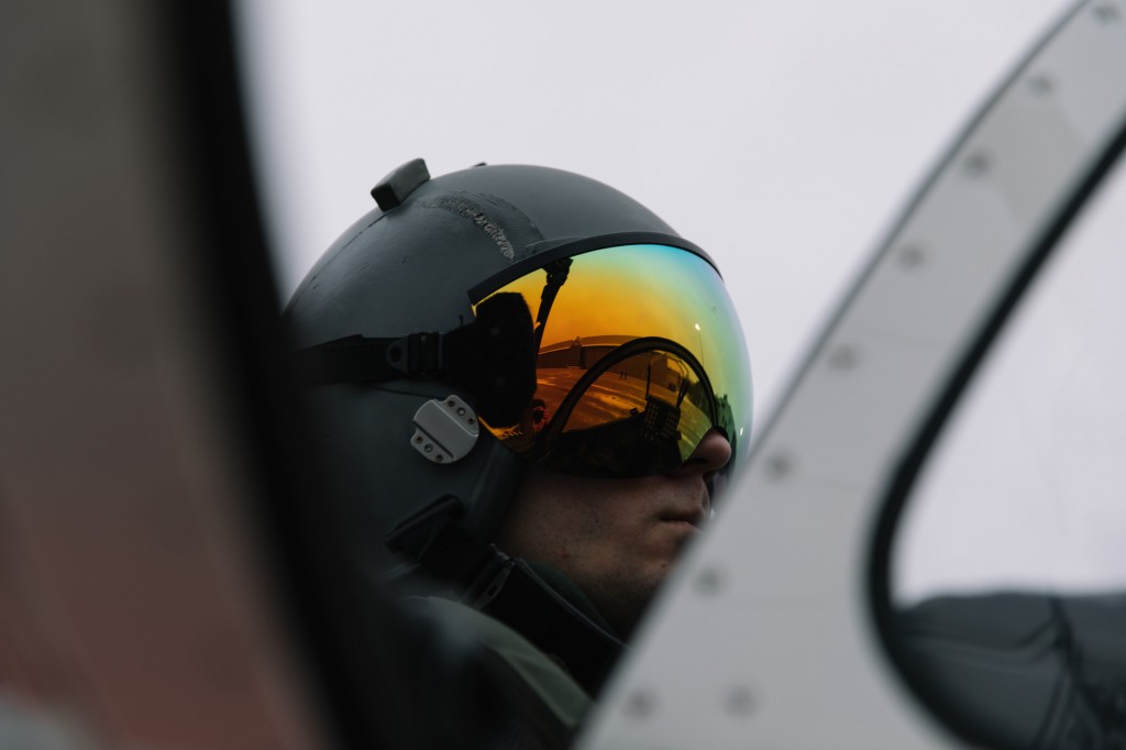 image of a pilot sitting in a cockpit wearing a helmet