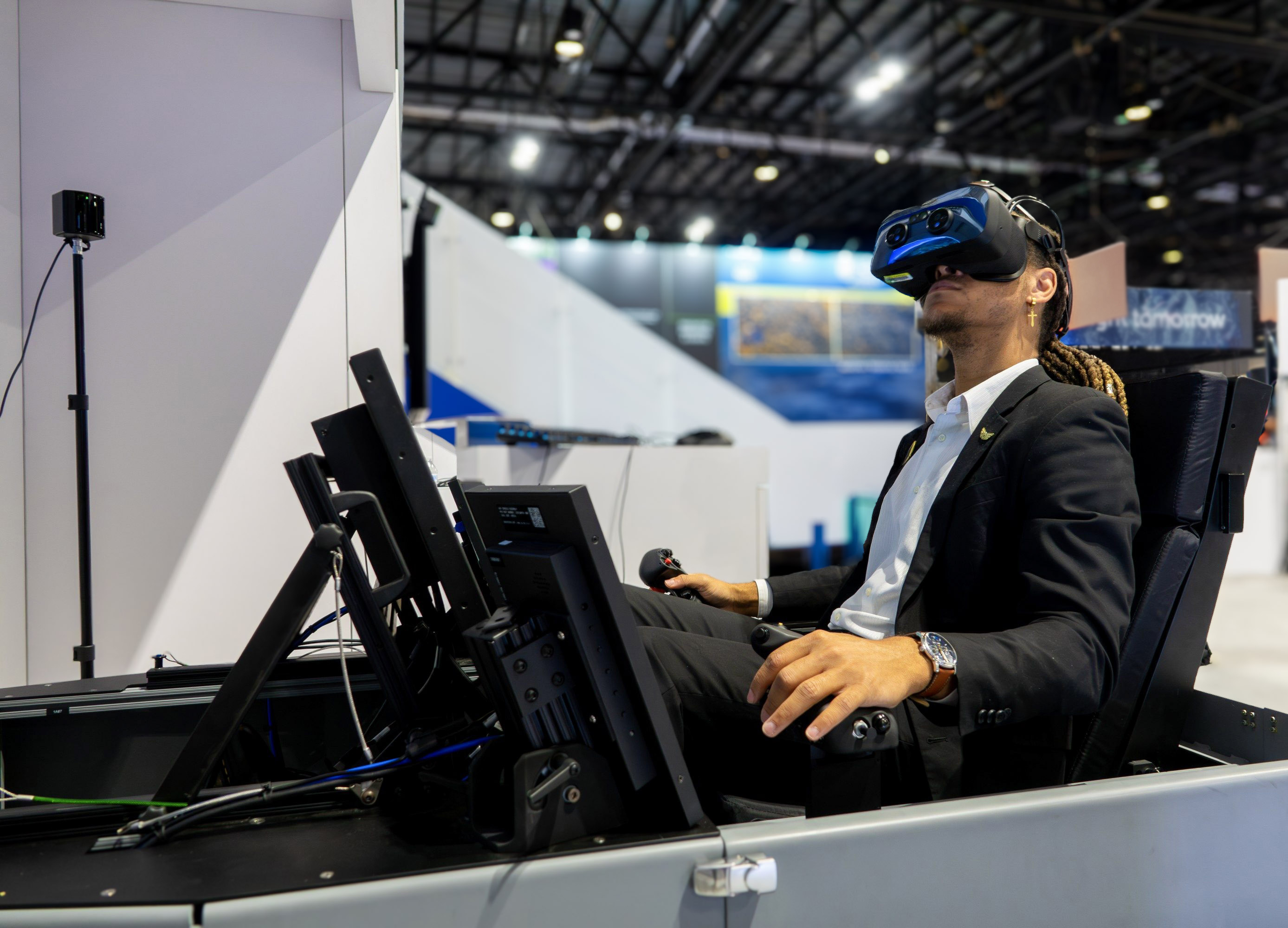 A person sitting in a flight simulator, wearin an XR headset