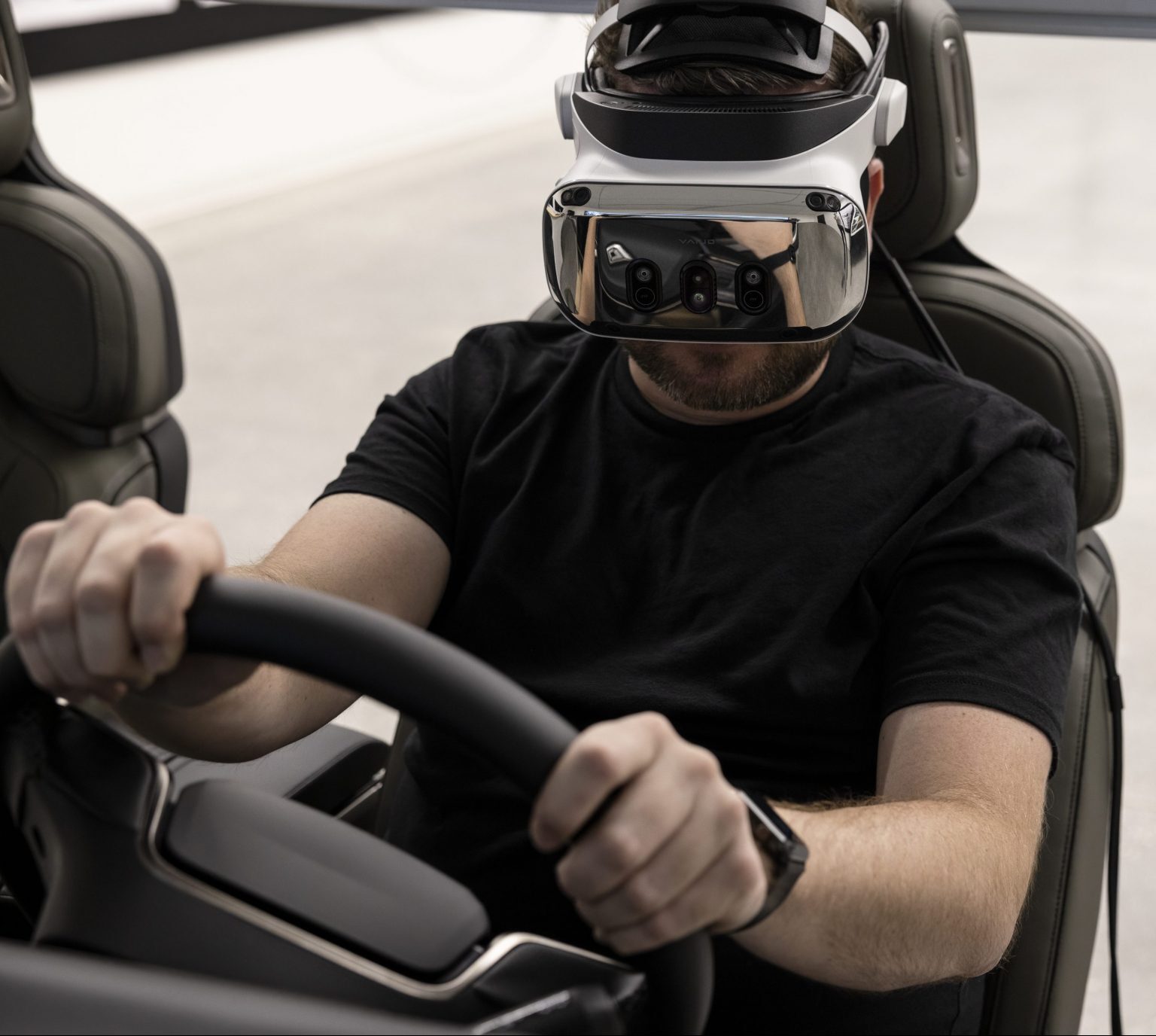 A person sitting behind a wheel wearing an XR headset