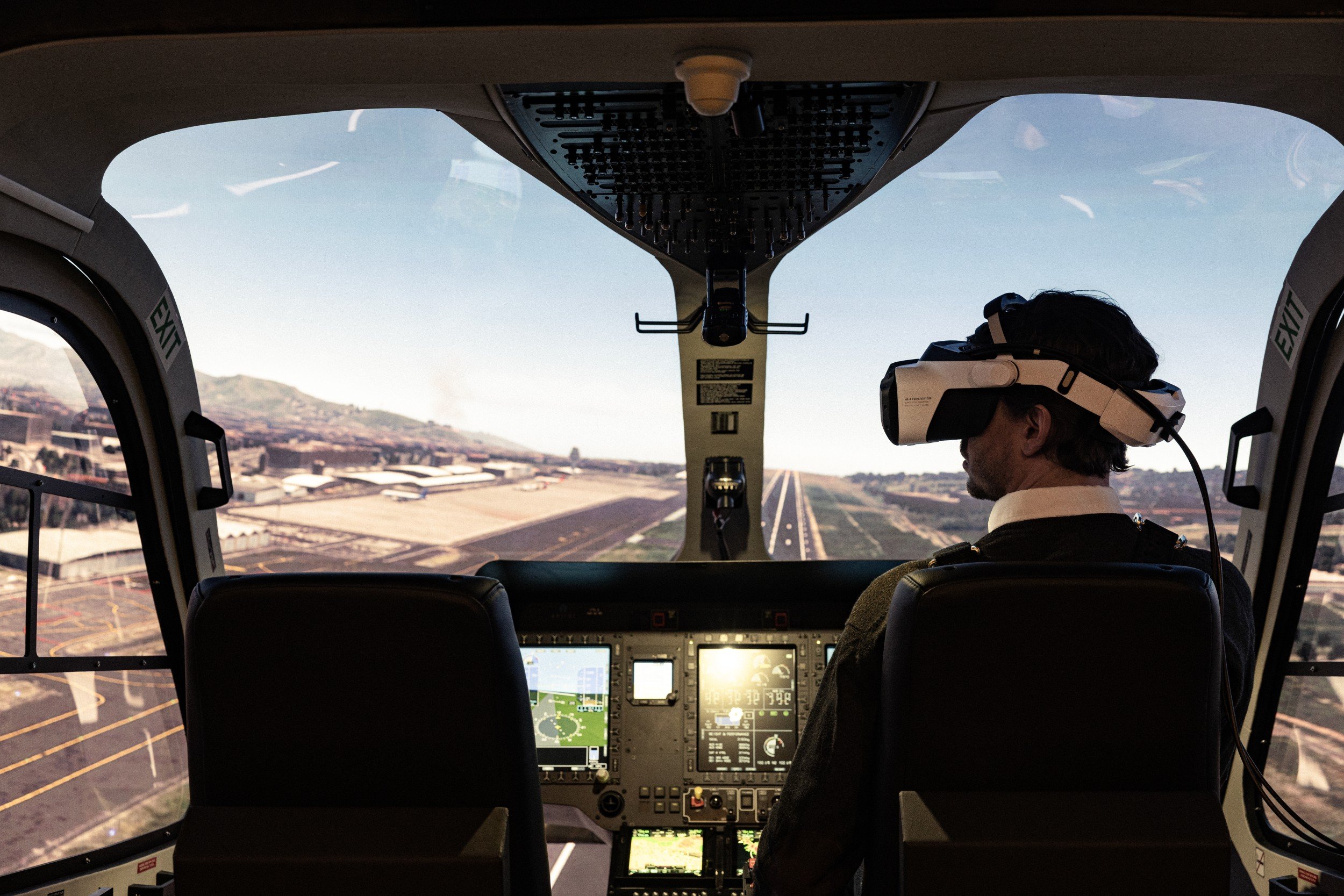 A person sitting in an airplane cockpit, wearing a XR headset.