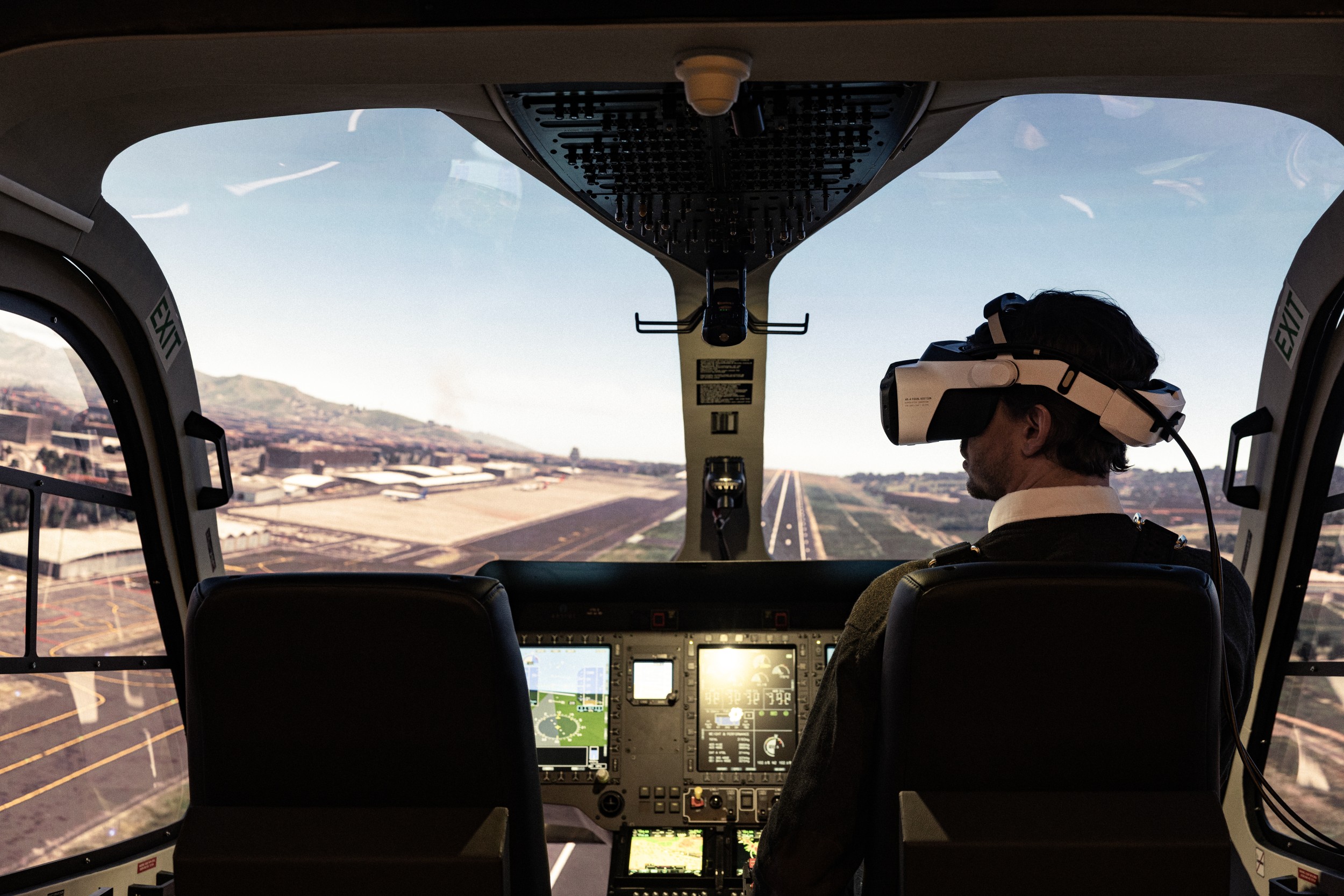 A person sitting in an airplane cockpit, wearing a XR headset.