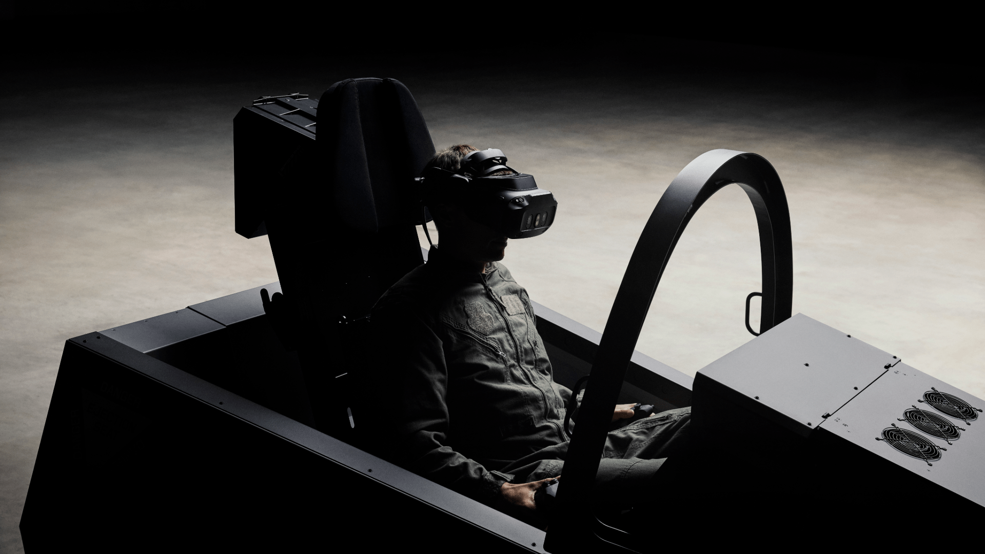 A person sitting in a flight simulator, wearing a VR headset