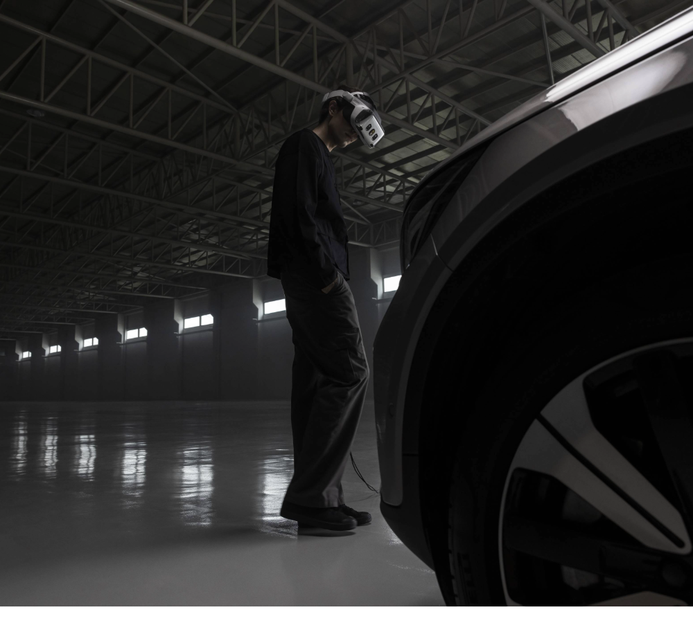 A person wearing a VR headset, inspecting a car