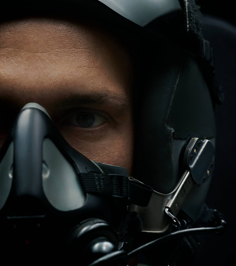A close up photo of a pilot wearing an oxygen mask 