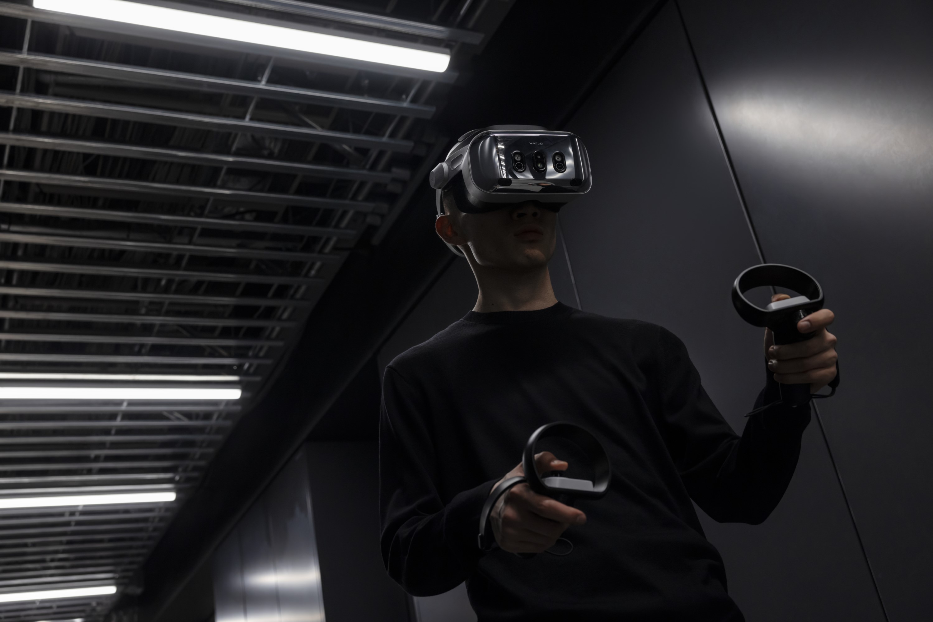A person wearing a VR headset, with controllers in his hands